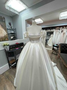 a white wedding dress on display in a store