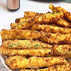 some fried food on a white plate with a cup and saucer in the background