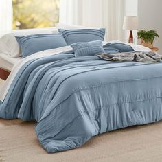 a bed with blue sheets and pillows in a room