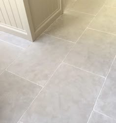 a bathroom with gray tile floors and white walls