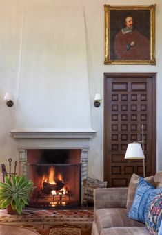 a living room filled with furniture and a fire place in front of a painting on the wall