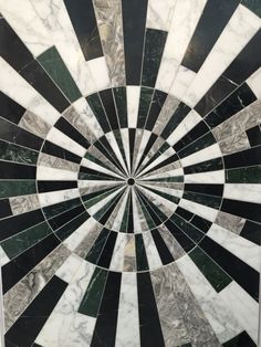 a black and white marble wall with a circular design in the center that looks like an optical illusion