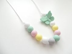 a necklace made out of plastic beads with a butterfly on it