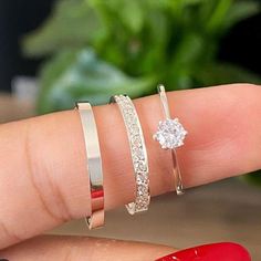 a woman's hand with three different rings on it