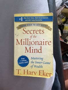 a book about the secrets of the millionaire mind by t harry elker on a chair