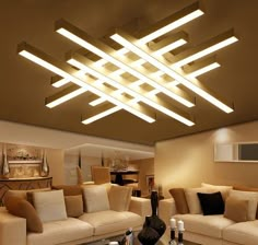 a living room with couches, tables and lamps on the ceiling is lit by recessed lights