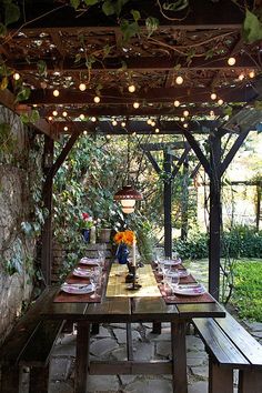 an outdoor dining area with wooden table and benches