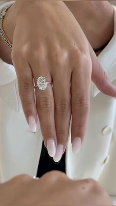 a close up of a person's hand with a diamond ring on their finger