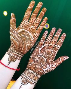 two hands with henna designs on them