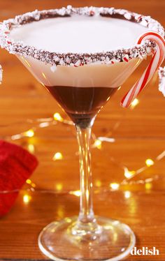 a chocolate martini is garnished with candy canes and powdered sugar on the rim