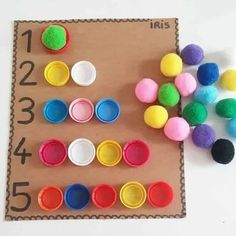 a table topped with lots of different colored cupcakes next to numbers on a piece of cardboard