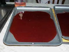 two pans filled with red liquid sitting on top of a counter