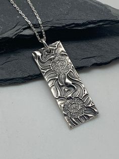 This Art Nouveau bar necklace has been entirely handmade using .999 fine silver. It has been cut from fine silver precious metal clay, textured, fired and oxidized. The pendant hangs from a sterling silver diamond cut cable chain. This fine silver pendant features an embossed Art Nouveau style daffodil floral textured pattern. Pendant size: approximately 1 1/4 x 1/2 inches Chain length: adjustable at 16 and 18 inches can also be customized to whatever length needed The necklace is sent in a gift Artisan Sterling Silver Rectangular Necklace, Silver Rectangular Etched Necklace, Silver Metal Clay Jewelry, Silver Clay Ideas, Silver Clay Jewelry Ideas, Jewelry Smithing, Art Nouveau Bar, Silver Clay Jewelry, Metal Clay Designs