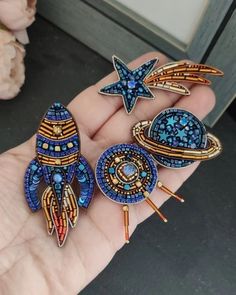 three brooches in the palm of someone's hand