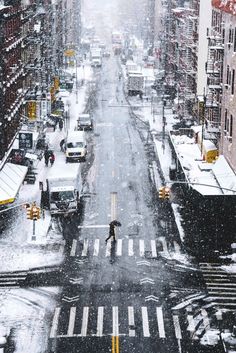 a person walking across a street in the snow