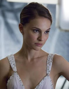 a beautiful young woman in a white dress looking at the camera with an intense look on her face