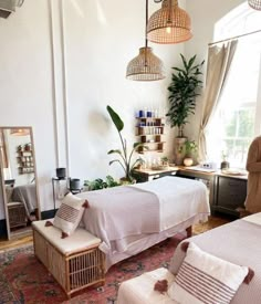 a bedroom with two beds and plants in the corner