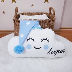 a pillow with a face on it that says logan next to a wicker basket