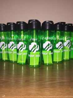 several green sports bottles lined up on a table