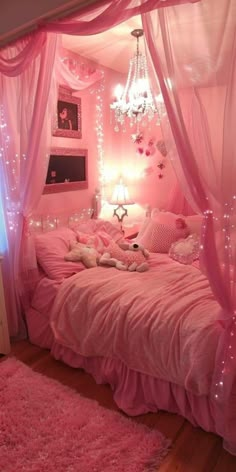 a bed with pink sheets and lights in a room that is decorated like a princess's bedroom