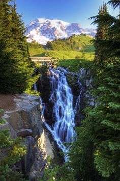 a large waterfall surrounded by trees and mountains