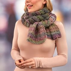 a woman wearing a pink top and a crocheted scarf