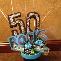 a blue bucket filled with chocolates and candy on top of a carpeted floor