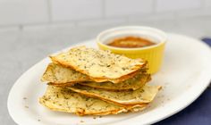 some crackers on a white plate with dipping sauce