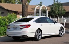 a white car parked in front of a house