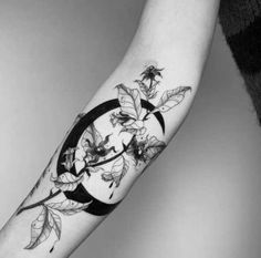 a black and white photo of a person's arm with flowers on it