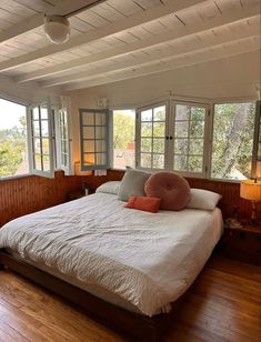 a bed sitting in a bedroom next to two windows