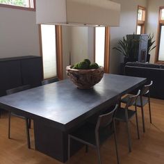 a table with chairs and a bowl on it in the middle of a living room