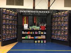 a news stand with various items on display in it's center area, including candy bars and candies