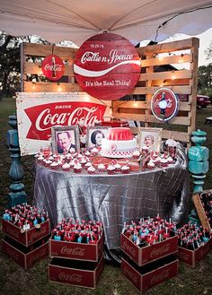 a table with coca - colas and other items on it at an outdoor event