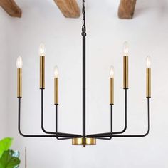 a black and gold chandelier with five candles hanging from the ceiling in a living room