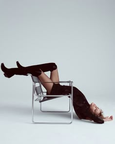 a woman laying on top of a chair with her legs spread out in the air