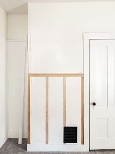 an empty room with two white doors and a black box on the floor in front of it