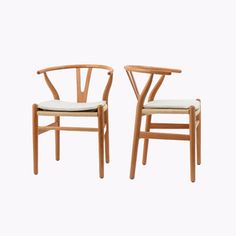 two wooden chairs sitting next to each other on top of a white surface with one chair facing the other