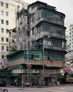 an old building with many windows and balconies on the top floor is surrounded by tall buildings