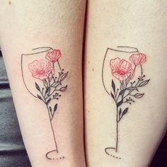 two tattoos on both legs with flowers and wine glasses in the bottom left arm area