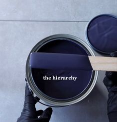 a person holding a paint can with the word the hierachy on it