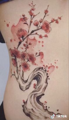 a woman's stomach with flowers and swirls painted on the side by tattoo artist junejun art