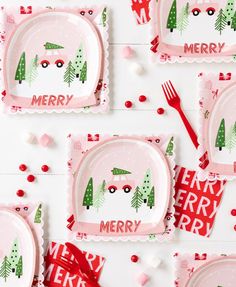 pink christmas plates and napkins with merry trees on them, surrounded by red bows