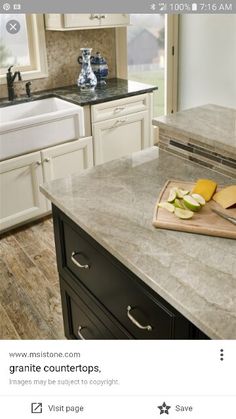 a kitchen with white cabinets and granite counter tops, along with an island in the middle