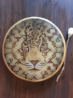 a decorative plate with a leopard face on it and two spoons next to it