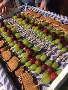 grapes and waffles are arranged on skewers to be served at a party