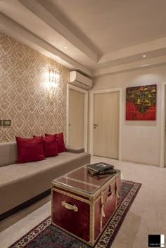 a living room with a couch, coffee table and rugs on the carpeted floor