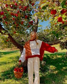 a woman standing in front of an apple tree