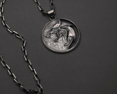 Monster Hunter Medallion, Silver Wolf Token, Fantasy Necklace, Sword Wielder Emblem, Beast Eye Pendant, Magic Symbol, Adventure Trinket Immerse yourself in folklore and magic with our Monster Hunter Medallion. This Silver Wolf Token is more than just a piece of jewelry; it symbolizes adventure, courage, and power. Our Fantasy Necklace holds the essence of an ancient, enchanted world where brave heroes wield their swords to protect the innocent. The Sword Wielder Emblem signifies the spirit of br The Witcher Medallion, Witcher Medallion, Witcher Geralt, Fantasy Necklace, Magic Symbols, Silver Wolf, Jewelry Details, White Wolf, Medallion Necklace