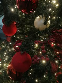 the christmas tree is decorated with red and white ornaments